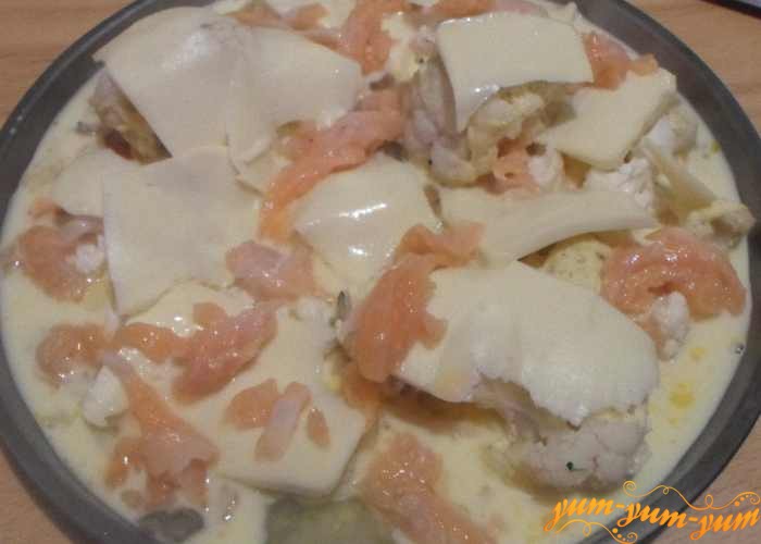 Сыр нарезать тонкими пластами и уложить сверху капусты
