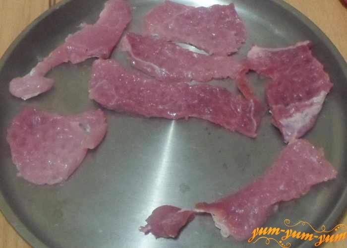 Отбитые кусочки мяса выложить на противень или форму для запекания