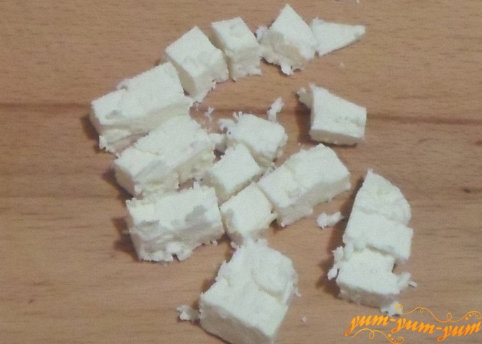 Сыр нужно нарезать мелкими кубиками и добавить к овощам